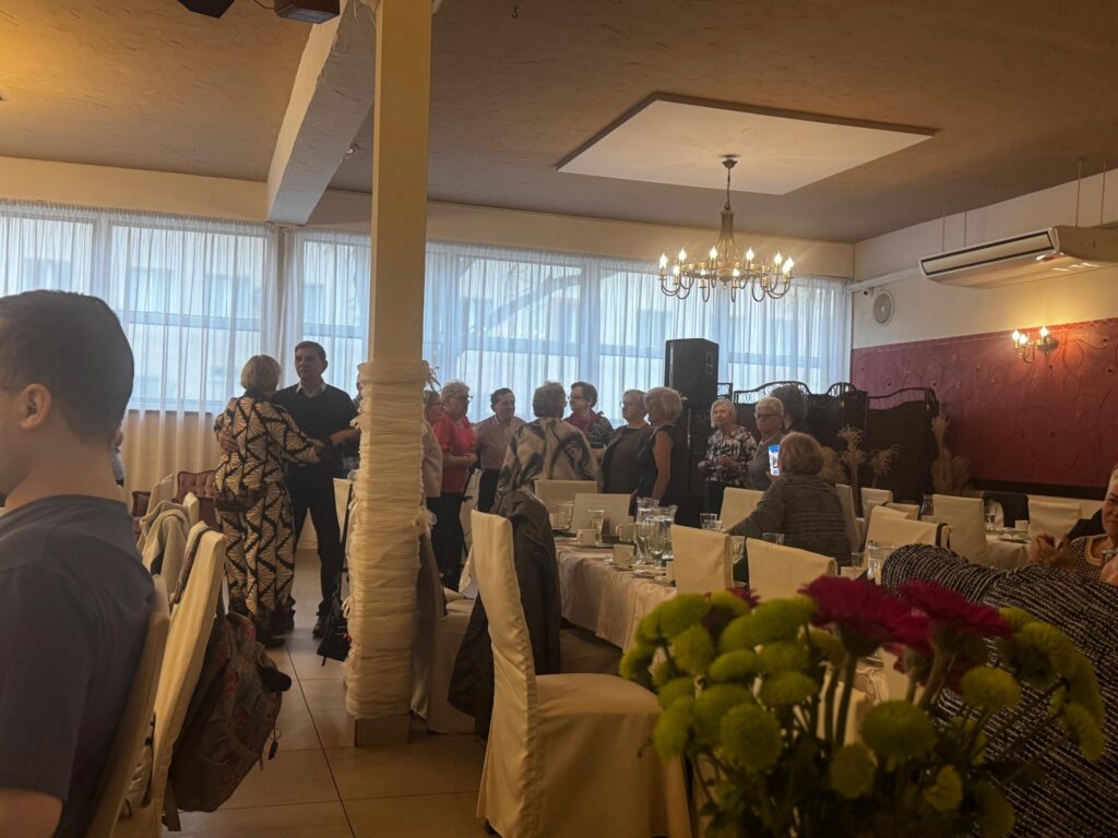 Uczestnicy obchodów Międzynarodowego Dnia Białej Laski w restauracji Hacjenda w Gdańsku Wrzeszczu. Sala udekorowana elegancko, przy stołach z białymi obrusami i kwiatami bawi się około 80 osób z dysfunkcją wzroku wraz z przewodnikami. W tle widoczny sprzęt muzyczny zespołu Impuls, który umilał spotkanie śpiewem i muzyką.